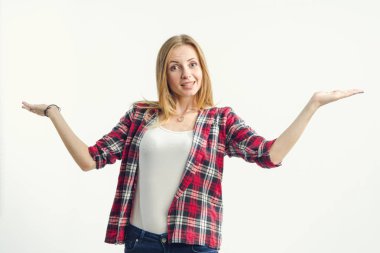 Güzel kadın ışık arka planda ayakta iken farklı yönlere ellerini kaldırdı. Metin için bir yeri işaret etme.