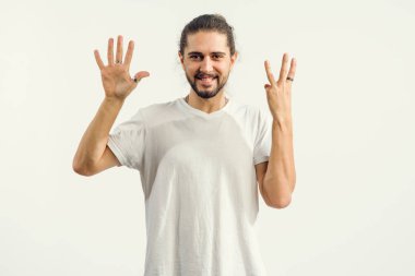 Sakallı genç adam parmaklarıyla elini kaldıran 8 numarayı gösteriyor..