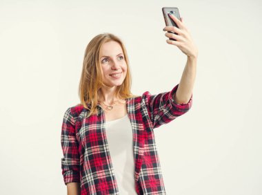 Akıllı telefonda selfie fotoğrafı çekiyorum. Selfie portresi çeken sarışın kadın. 