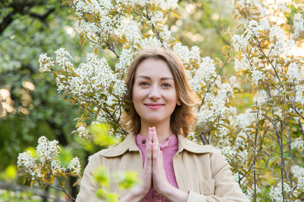 Portrait of a beautiful woman in the colors of spring park. Meditation.