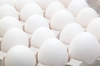 Yakın çekim beyaz tavuk yumurtası. Kümes hayvanları ürünleri yetiştiriciliği ve satışı hakkında bir arka plan görüntüsü için konsept.
