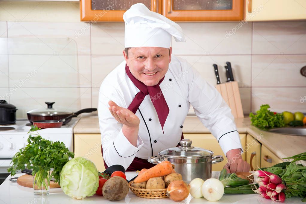 Portrait of a male cook in the kitchen. Male chef cooks food.