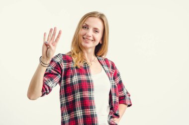 Güzel genç kadın hafif bir arka plan üzerinde dururken dört parmak gösterir. Sayı 4.