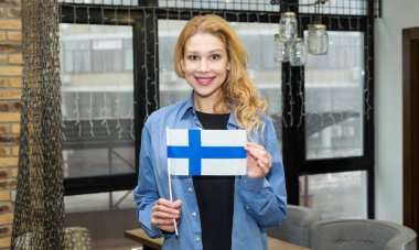 Finlandiya bayrağı olan güzel sarışın kadın. İskandinavya'ya seyahat et. Fince Öğrenin.