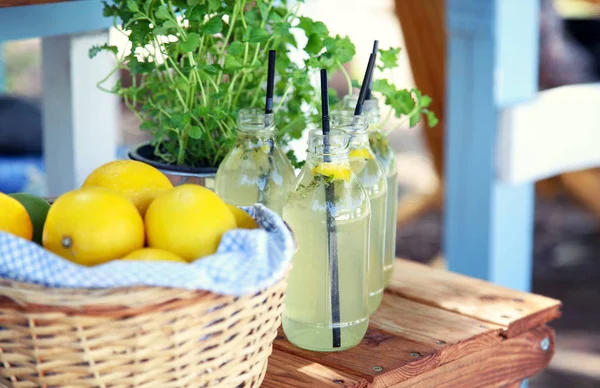 테이블에 레몬을 곁들인 신선한 레모네이드와 바구니 — 스톡 사진
