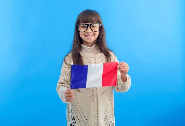 青い背景に立つフランスの旗を持つ小さな女の子 留学中の女子学生 — ストック写真