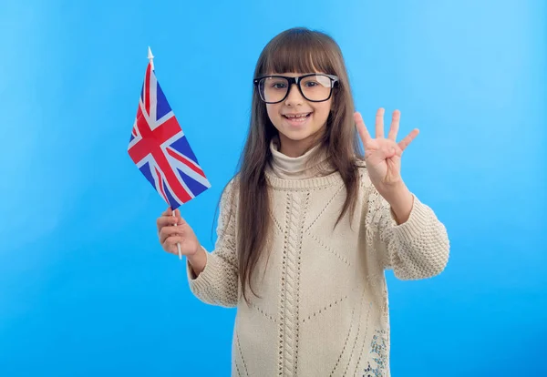 Dziewczynka Flagą Zjednoczonego Królestwa Wielkiej Brytanii Pokazuje Cztery Palce Niebieskim — Zdjęcie stockowe