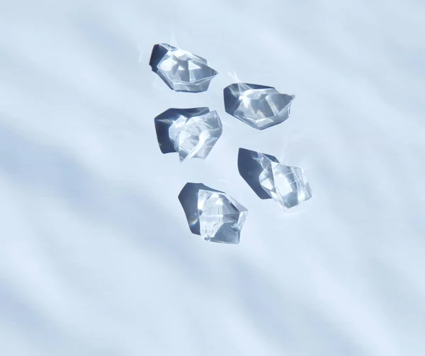 Five white crystals under water. View from above. — Stock Photo, Image