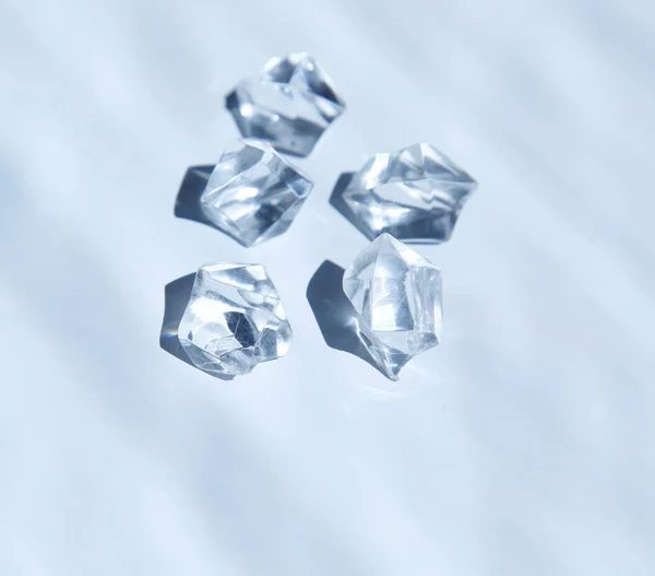 Five white crystals under water. View from above. — Stock Photo, Image