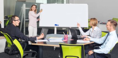 İş kadını ofiste bir sunum yapıyor. Müdür çalışanlarla konuşur. Yeni projenin planına söyleyin.