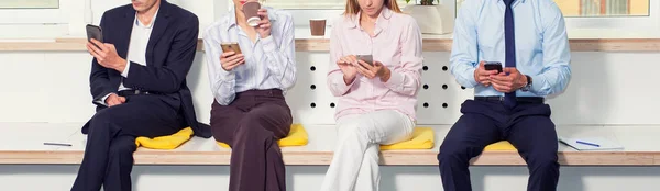 Bir grup iş adamı, yüzleri olmayan, ofiste otururken akıllı telefon kullanıyor. Kahve molası. Toplantı bekleniyor.