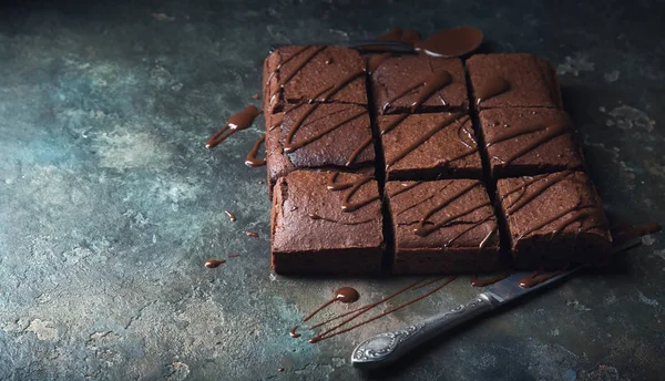 Brownie cake dessert. Dark sponge cake with cocoa and chocolate on a old textural table.