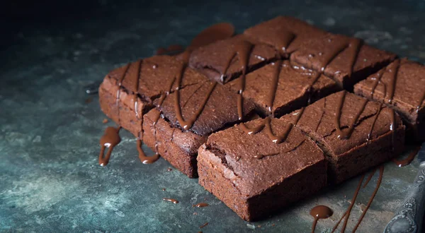 Brownie cake dessert. Dark sponge cake with cocoa and chocolate on a old textural table.