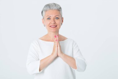 Olgun mutlu kadın asya tebrik ellerini katlanmış. Orta yaşlı kadın, elleriyle meditasyon yaptı. Kavram - sakin, ruhsal, inanç, barış.