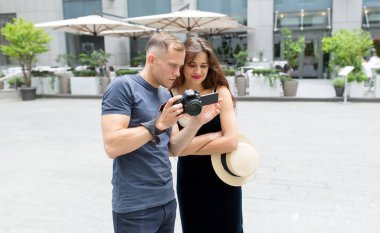 Profesyonel fotoğrafçı, müşterinin kameraya fotoğraf çektiği kızı gösteriyor. Fotoğraflamanın favori işi.