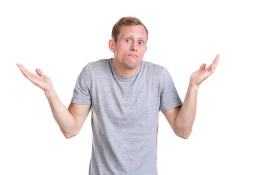 Beyaz bir arka plan üzerinde izole gri bir t-shirt sürpriz genç adam. Hayal kırıklığı duygusu.