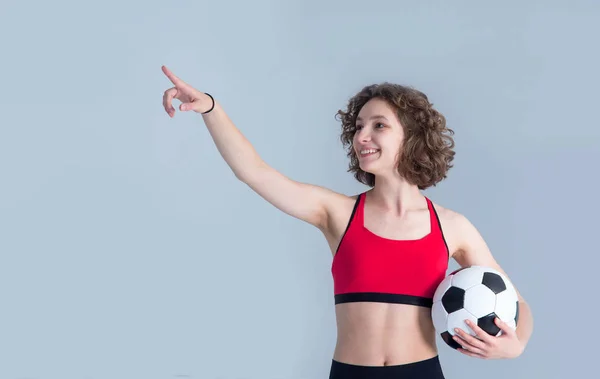 Mujer Joven Con Una Pelota Fútbol Apunta Hacia Lado Mientras —  Fotos de Stock