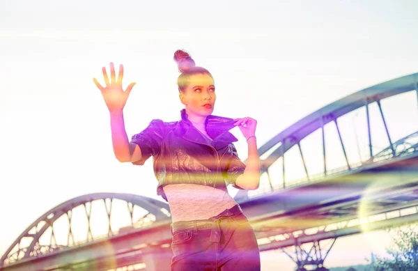 Cyber space, woman goes through a force field against the backdrop of an industrial bridge.