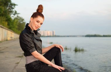 Gün batımında şehrin ve nehrin arka planında güzel bir kadının portresi..