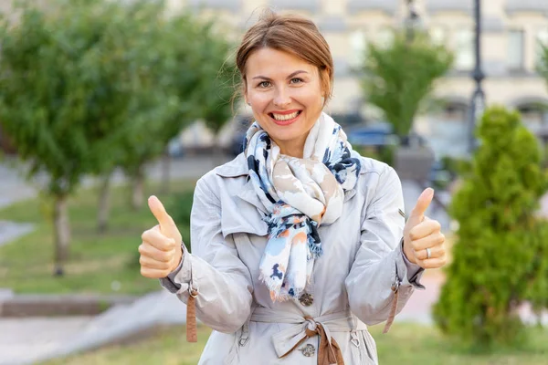 Beautiful Middle Aged Woman Shows Thumbs While Standing Backdrop City — Stock Photo, Image