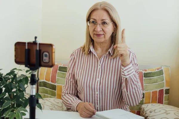 Mature Woman Points One Finger Talking Looks Smartphone Video Calling — Stock Photo, Image