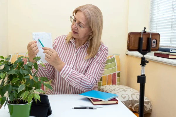 Mature Woman Teacher Conducts Online Training Looking Smartphone Showing Notes — Stock Photo, Image