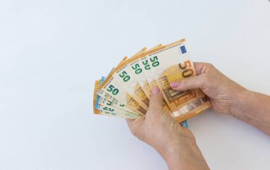 Son sınıf öğrencilerinin elleri masada oturan paraları sayıyor. Avrupa Birliği 'nin kağıt notları 50 avro değerinde.