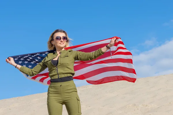 Woman hero with USA flag against blue sky. Freedom concept. America Independence Day.