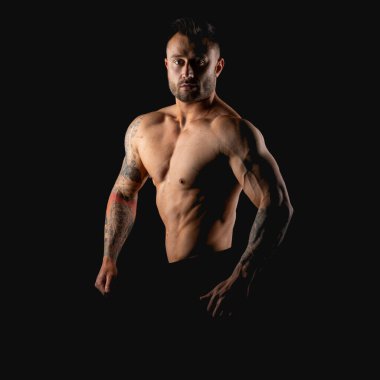 Güçlü bir adam. Siyah arkaplanda vücut geliştirici.