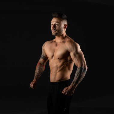 Güçlü bir adam. Siyah arkaplanda vücut geliştirici.