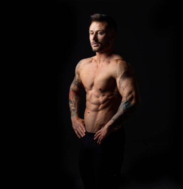 Siyah arka planda çıplak gövdesi olan bir erkek vücut geliştirici. Güçlü adam, stüdyo fotoğrafı..