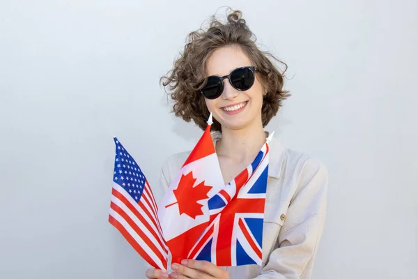 Smiling woman with flags USA, Canada, United Kingdom, countries of English language speaking. Study abroad.