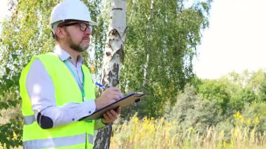 Ormandaki erkek ekolojist, çevrenin ekolojik durumunu kontrol ediyor. İnşaat, proje.