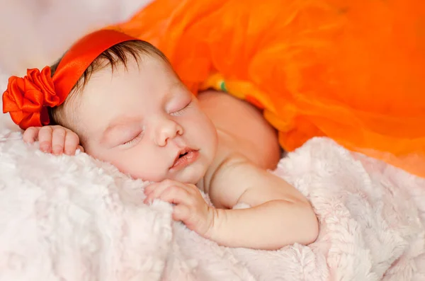 Slapende Pasgeboren Babymeisje Een Rood Lint Zijn Hoofd Een Oranje — Stockfoto