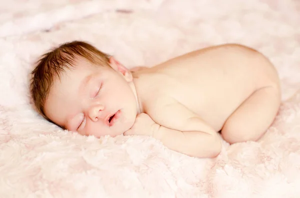 柔らかいふわふわの敷物の上で寝ている裸の生まれたばかりの赤ちゃん — ストック写真