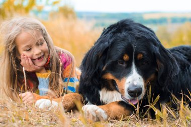 sonbahar üzerinde büyük köpek yanındaki kız yalan nın Sennenhund yürümek