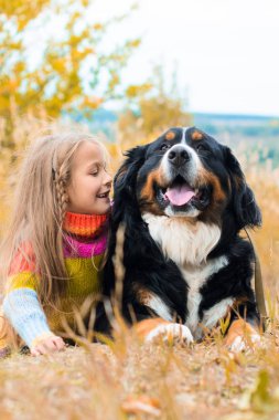 sonbahar üzerinde büyük köpek yanındaki kız yalan nın Sennenhund yürümek
