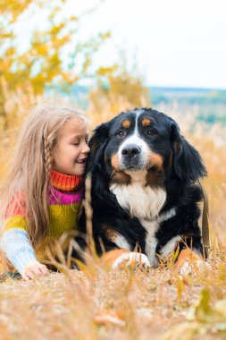 sonbahar üzerinde büyük köpek yanındaki kız yalan nın Sennenhund yürümek