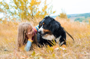 sonbahar üzerinde büyük köpek yanındaki kız yalan nın Sennenhund yürümek