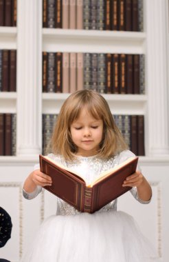 kitaplığındaki kitap rafı arka plan üzerinde beyaz okuma kitabı, sevimli küçük kız