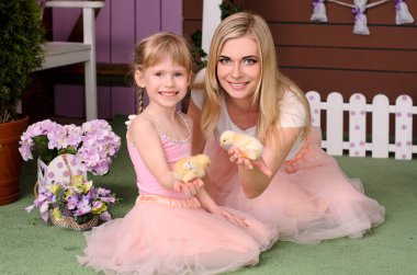 Anne ve kızı aynı elbise, gömlek ve etek burada, onun elleri tavuklarda holding