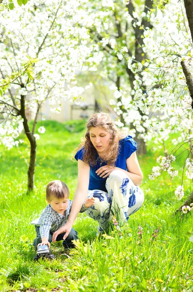 Mamá Juega Con Pequeño Hijo Hierba Exuberante Jardín Primavera —  Fotos de Stock