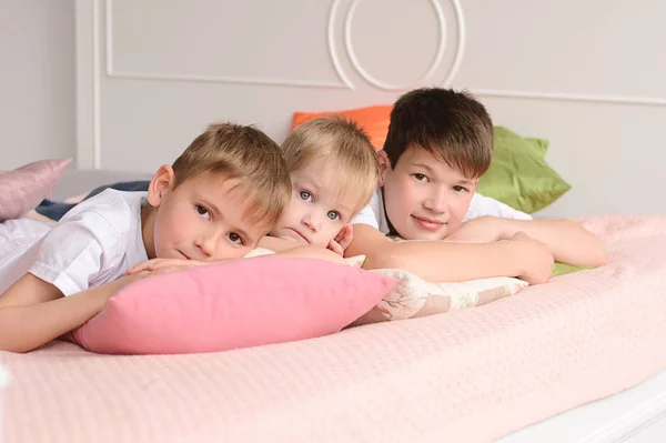 Drie Jongens Liggend Een Bed Van Kleurrijke Kussens — Stockfoto