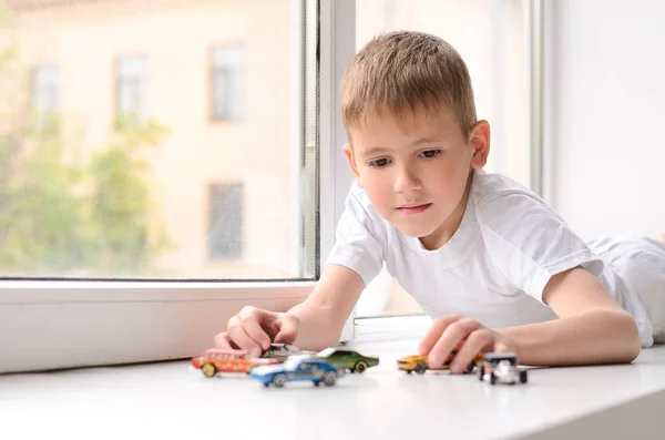 Junge Weißen Hemd Liegt Und Spielt Spielzeugautos Auf Der Fensterbank — Stockfoto