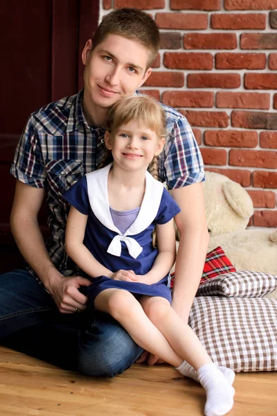 Dad Sits Her Daughter Her Arms Background Brick Wall — Stock Photo, Image