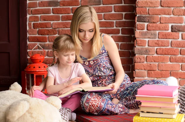 Moeder Lezen Van Een Boek Met Haar Dochter Een Achtergrond — Stockfoto