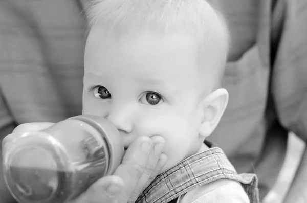 Liten Blond Pojke Drycker Från Flaska Vatten Händerna Fadern — Stockfoto