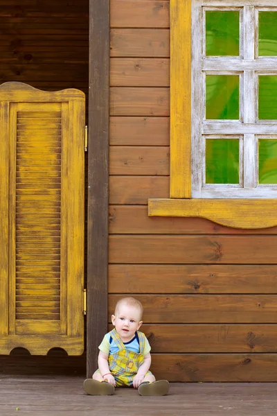 Bambino Seduto Sul Pavimento Legno Sullo Sfondo Una Casa Legno — Foto Stock