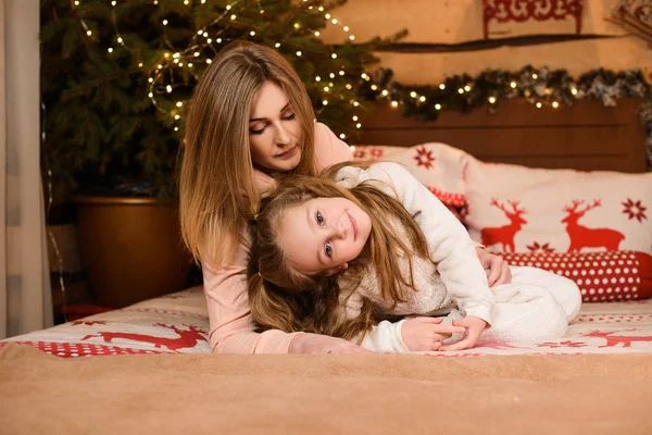Matka Dcera Leží Posteli Pozadí Bokehu Vánočních Světel Stromě — Stock fotografie