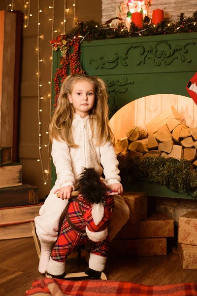 Girl Riding Toy Horse Festive Christmas Fireplace — Stock Photo, Image